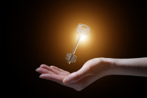 business woman holding shining key in a dark